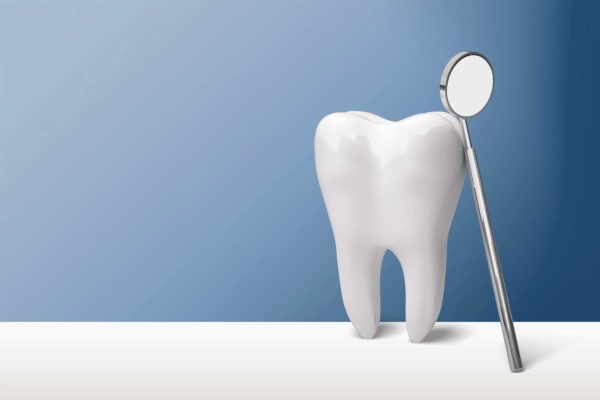 Tooth and mirror on blue background